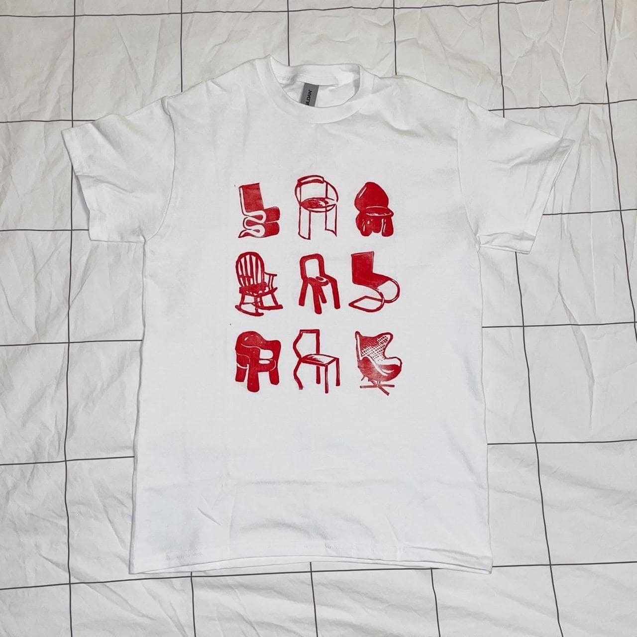White t-shirt with red collage of different chair designs